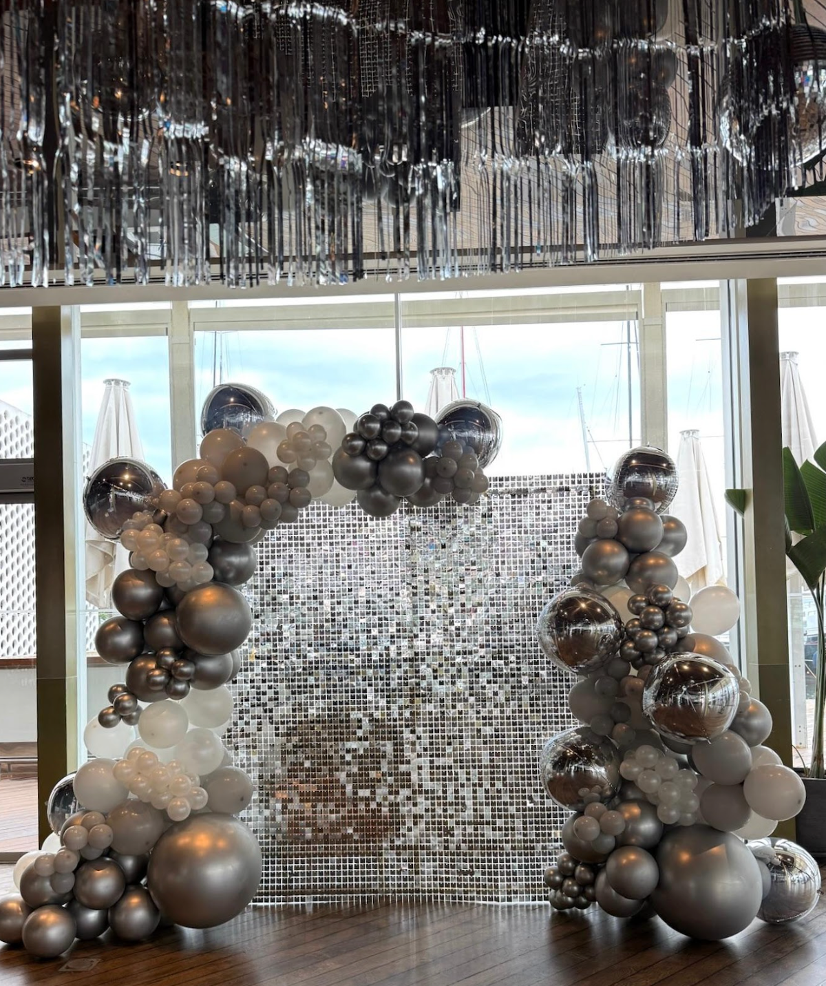 Balloon decoration installation with an elegant garland and event backdrop for a celebration.