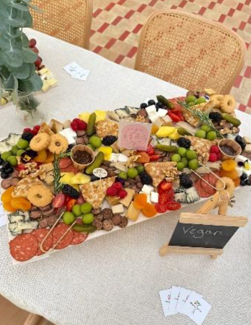 Beautifully styled vegan grazing platter featuring plant-based cheeses, vegan charcuterie, fresh and dried fruits, olives, nuts, crackers, and artisan spreads, elegantly arranged on a wooden board for a stylish and inviting event setup.