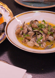 Two plates of seafood dishes on a dark surface