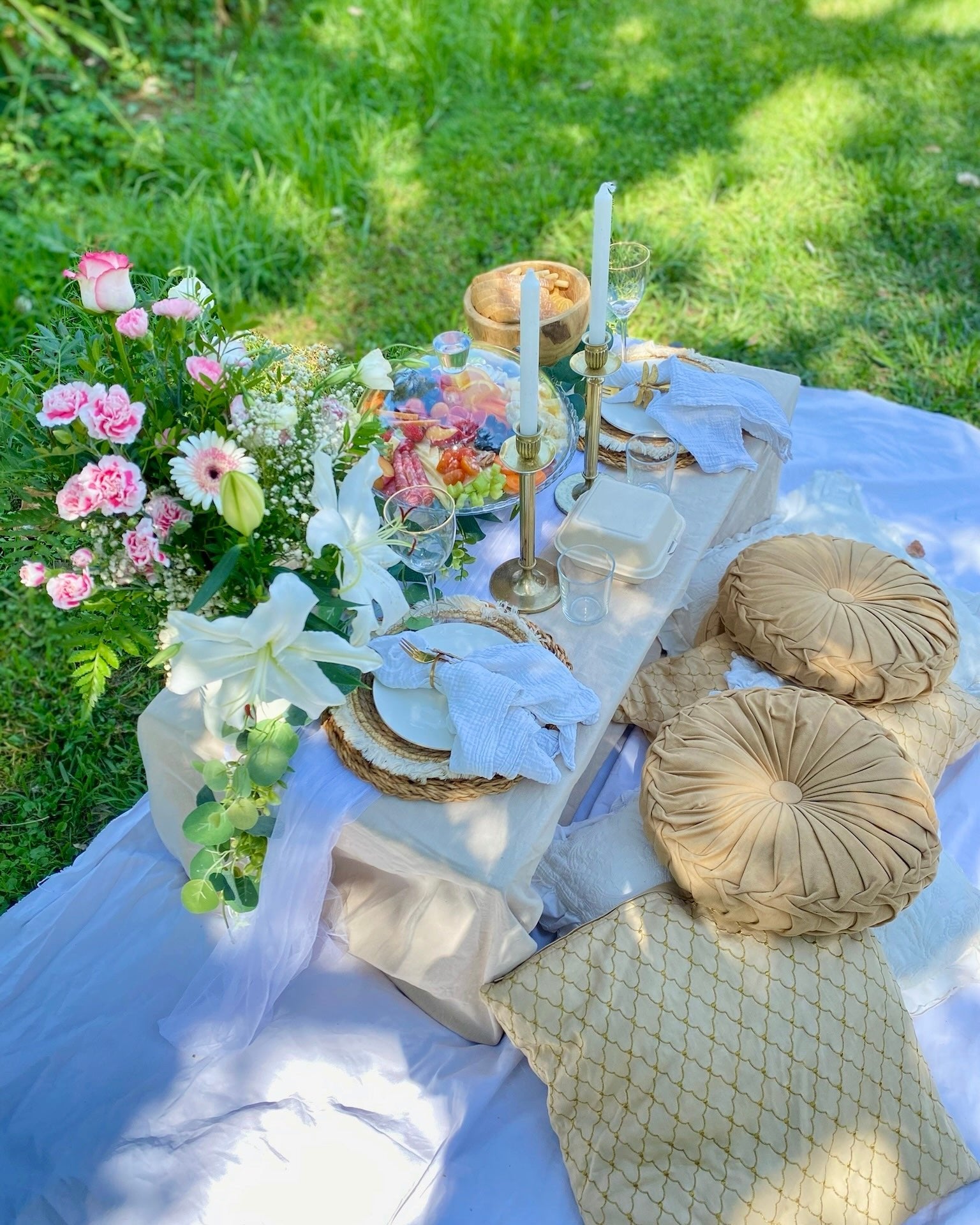 Beautiful romantic picnic arrangement with a luxurious grazing platter, soft cushions, a cozy blanket, and floral accents, perfect for a couple’s outdoor getaway in Maresme. 