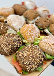 Assorted bread rolls with fillings on a wooden board for corporate catering