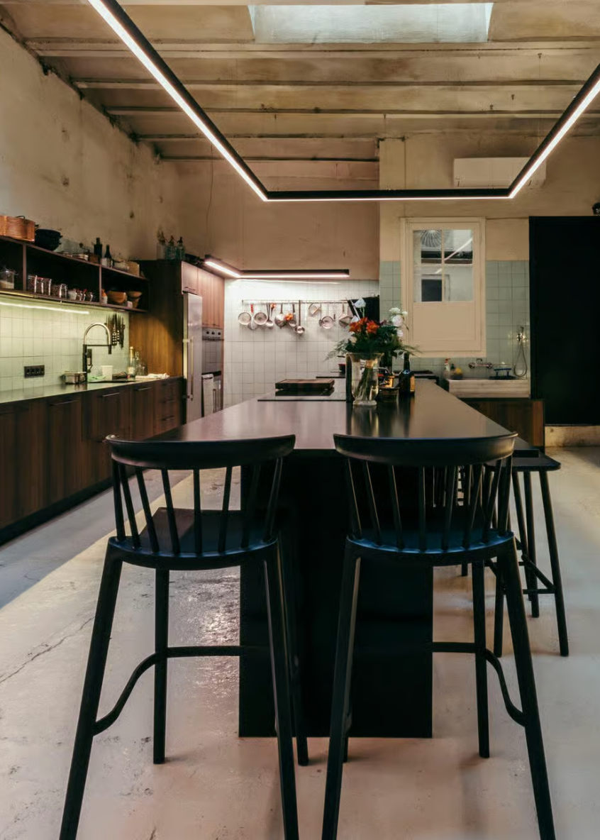 Modern kitchen with wooden island and black chairs