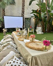 Cozy outdoor movie night and picnic setup with blankets, pillows, a projector screen, and a grazing platter, surrounded by string lights under the stars in Barcelona.