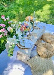 Decorative table setting with flowers and tableware on a grassy background
