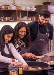 Three people cooking together in a kitchen