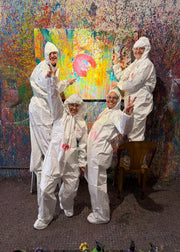 Five people in white protective suits posing in front of a colorful abstract painting.