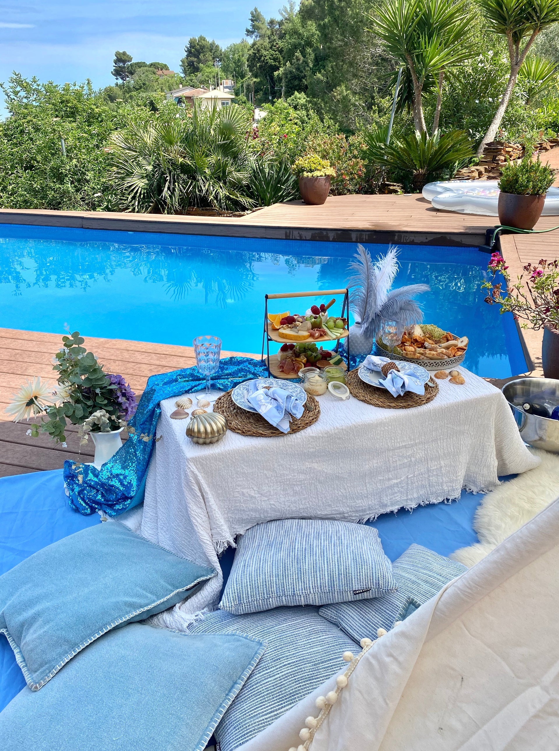 Charming romantic picnic setup with a picnic basket, gourmet treats, plush pillows, and candles, creating a cozy atmosphere for a couple's outdoor rendezvous in Maresme. 